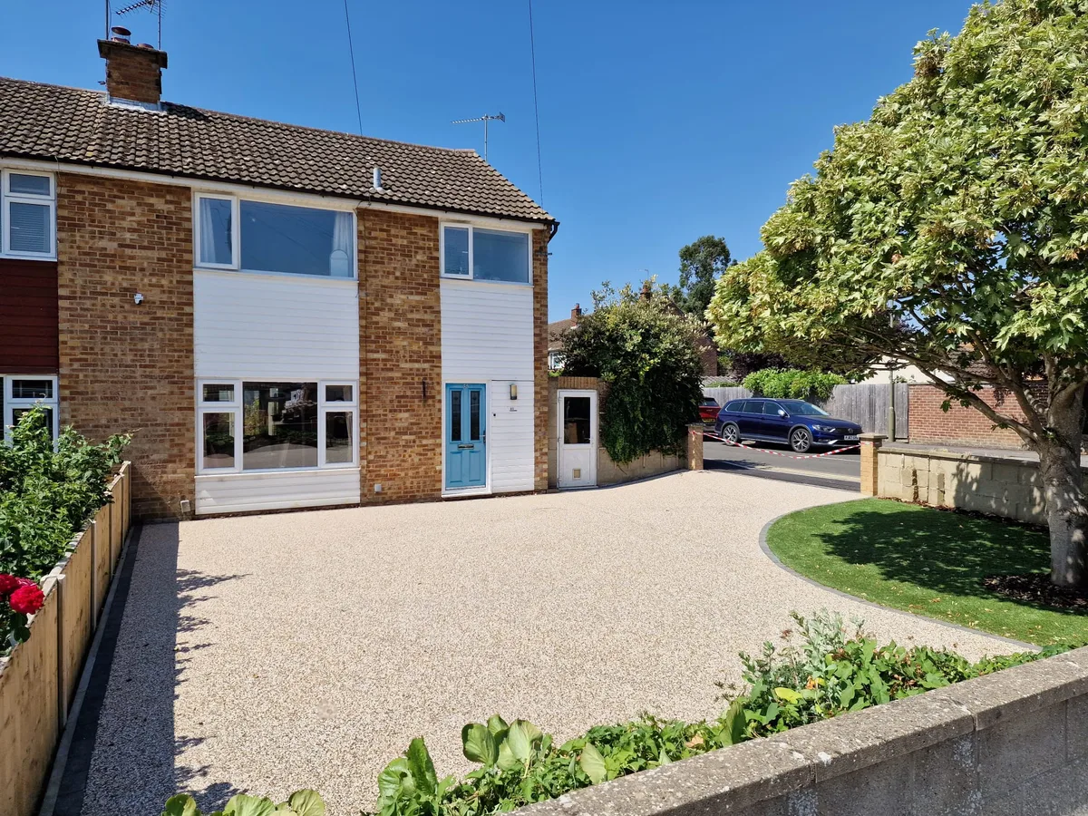 Completed light-coloured resin-bound driveway with curved lawn border in Bicester, Oxfordshire