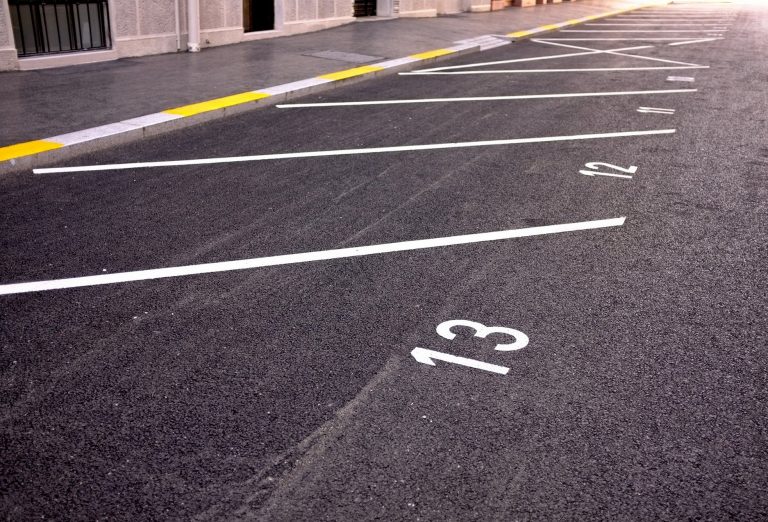 Numbered parking bays and safety markings on a commercial car park